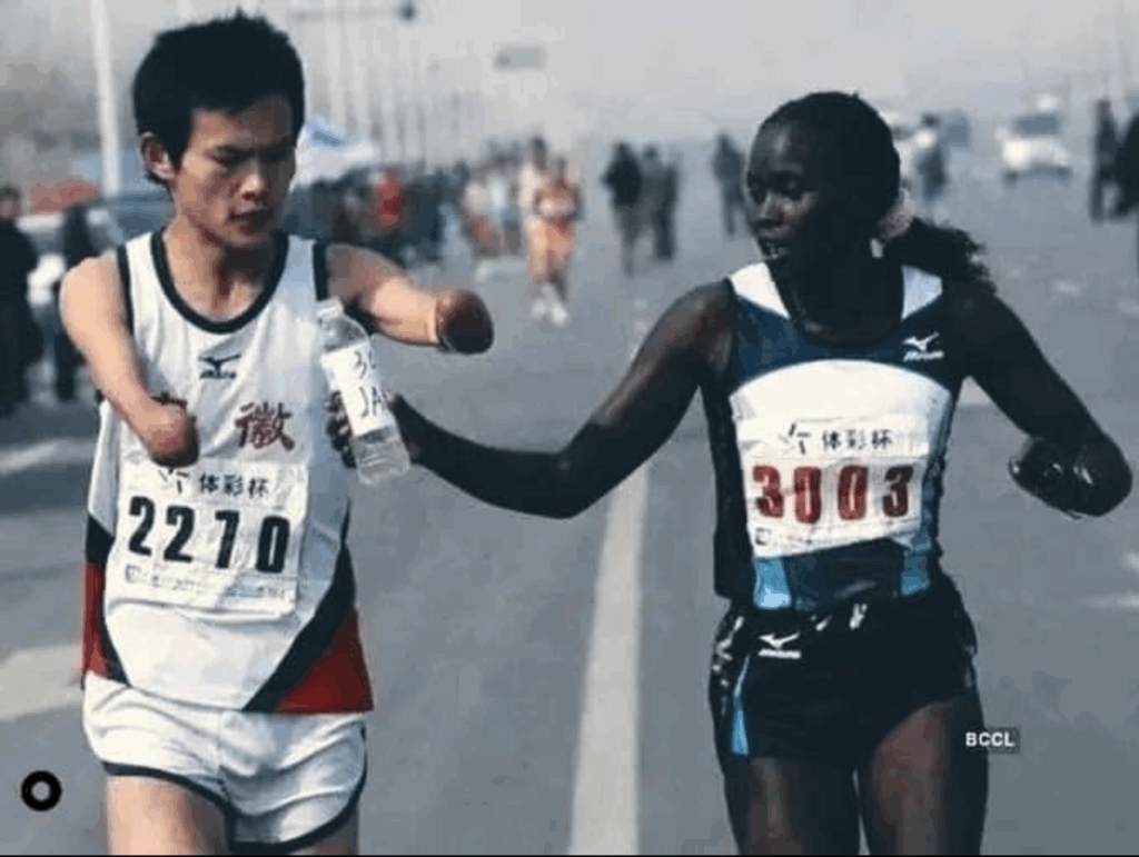 Elite runner Jaqueline Kiplimo helps a disabled Chinese athlete drink during the 2010 Zheng-Kai marathon.