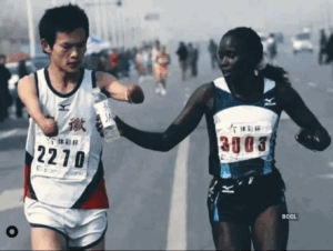 Elite runner Jaqueline Kiplimo helps a disabled Chinese athlete drink during the 2010 Zheng-Kai marathon.